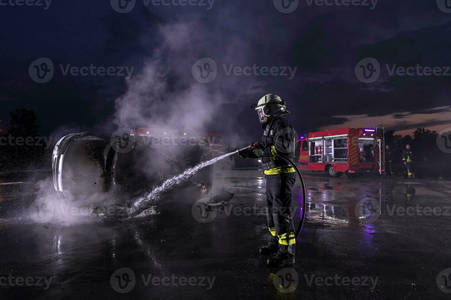 Firefighters fight the fire flame to control fire not to spreading out. Firefighter industrial and public safety concept. Traffic or car accident rescue and help action. photo