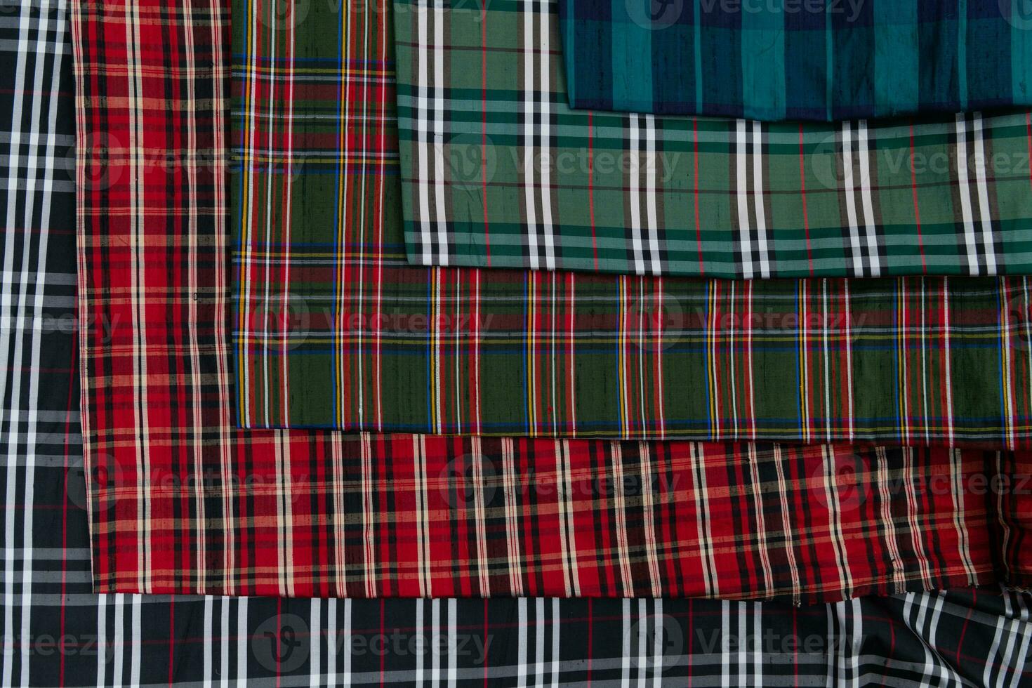 Collection of Scottish fashionable fabrics . Samples of different natural fabrics for sewing a fashion collection of clothes. Large selection of fabrics in the store or tailor warehouse. photo