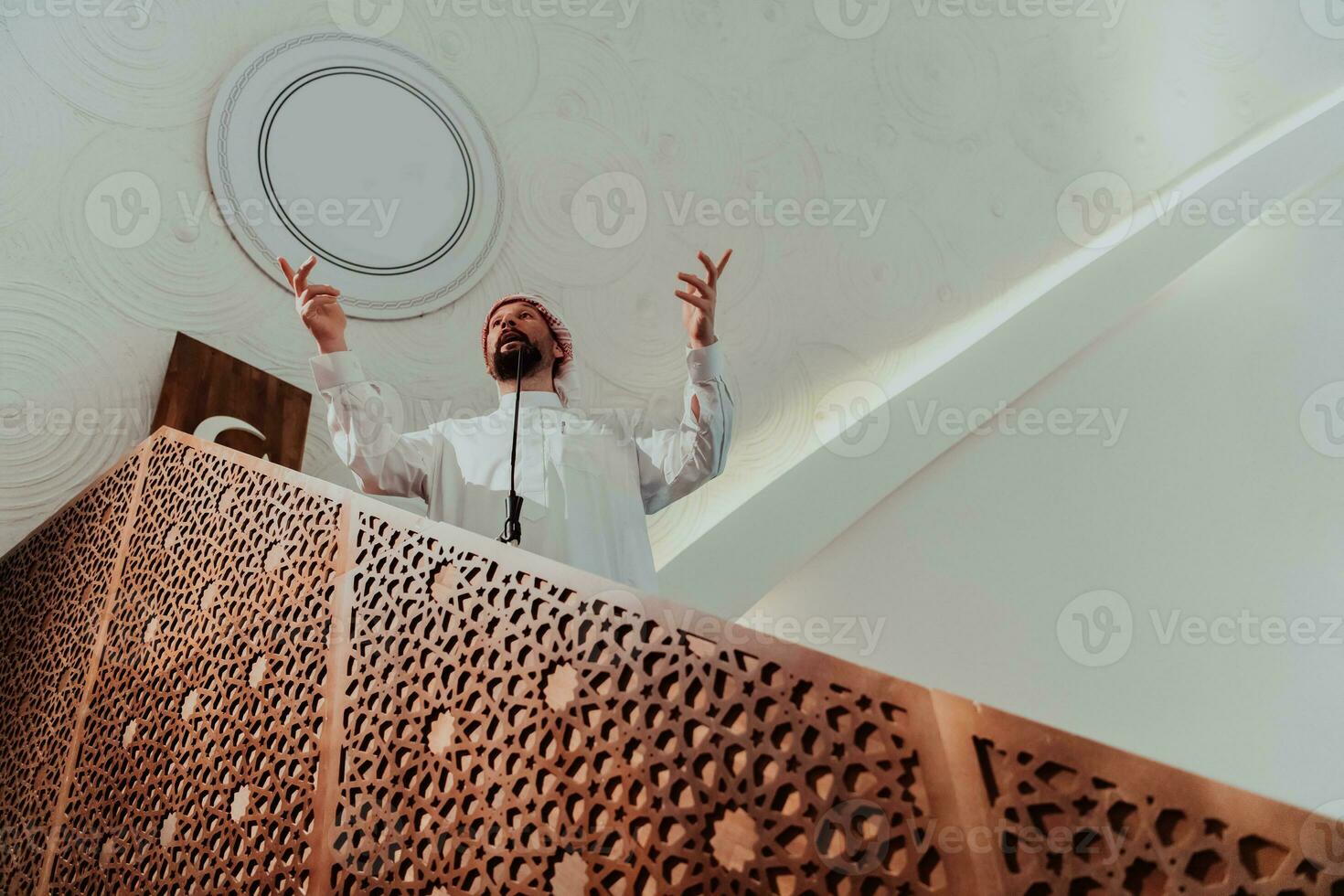 Muslims arabic Imam has a speech on friday afternoon prayer in mosque. Muslims have gathered for the friday afternoon prayer in mosque and are listening to the speech of imam photo