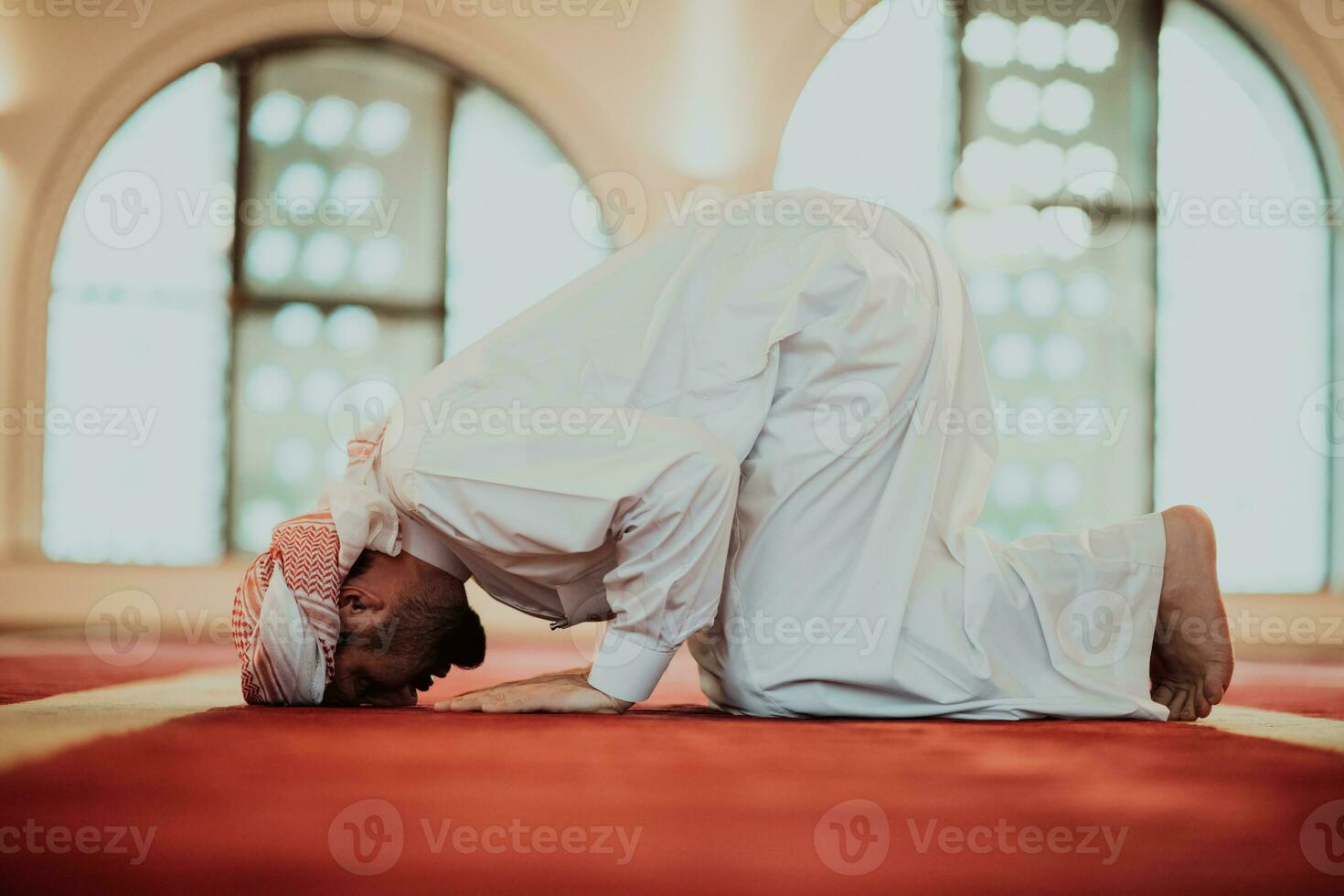un musulmán Orando en un moderno mezquita durante el santo musulmán mes de Ramadán foto