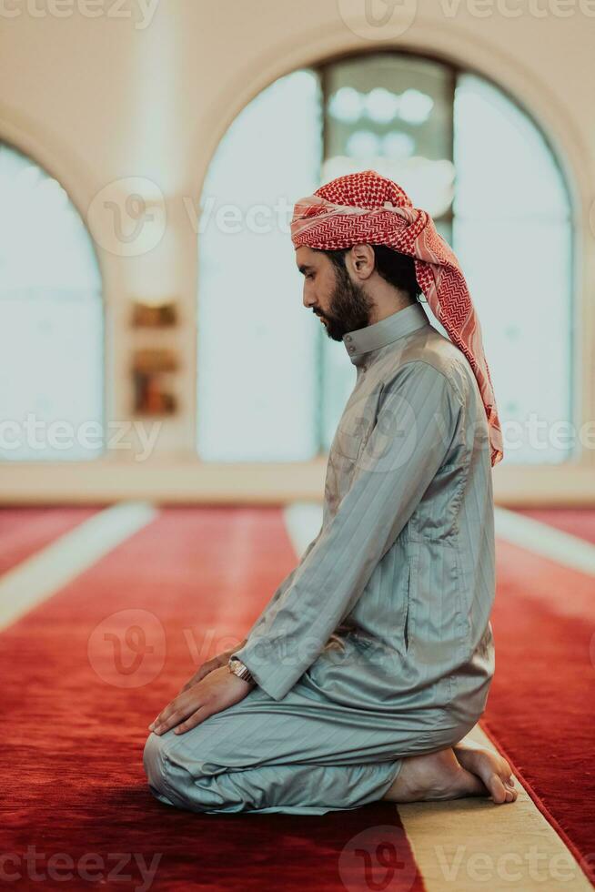 A Muslim praying in a modern mosque during the holy Muslim month of Ramadan photo
