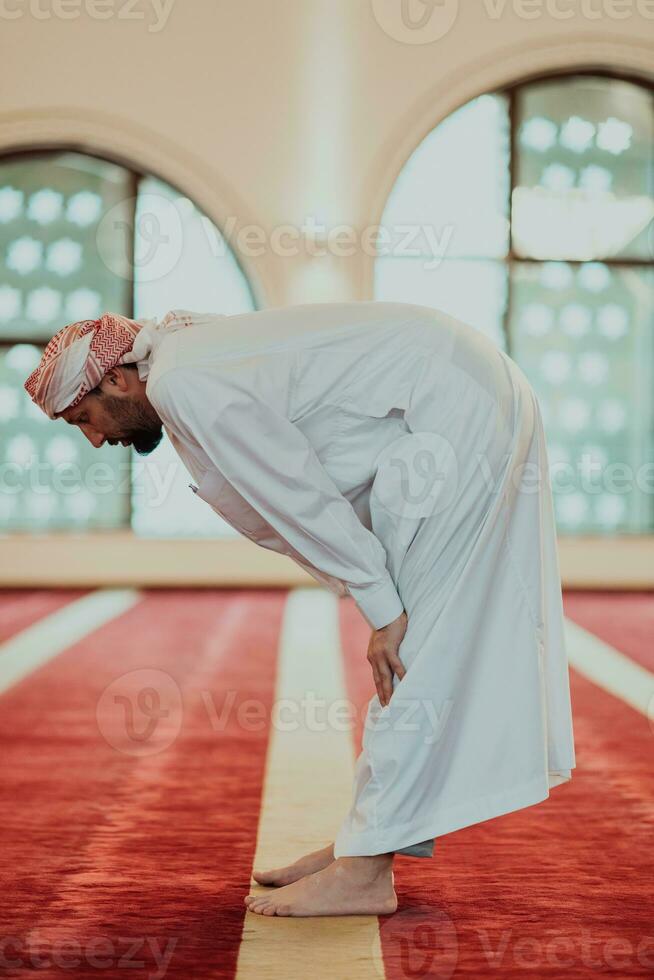 A Muslim praying in a modern mosque during the holy Muslim month of Ramadan photo