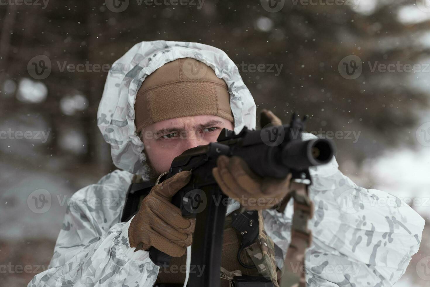 Winter war in the Arctic mountains. Operation in cold conditions.Soldier in winter camouflaged uniform in Modern warfare army on a snow day on forest battlefield with a rifle. Selective focus photo