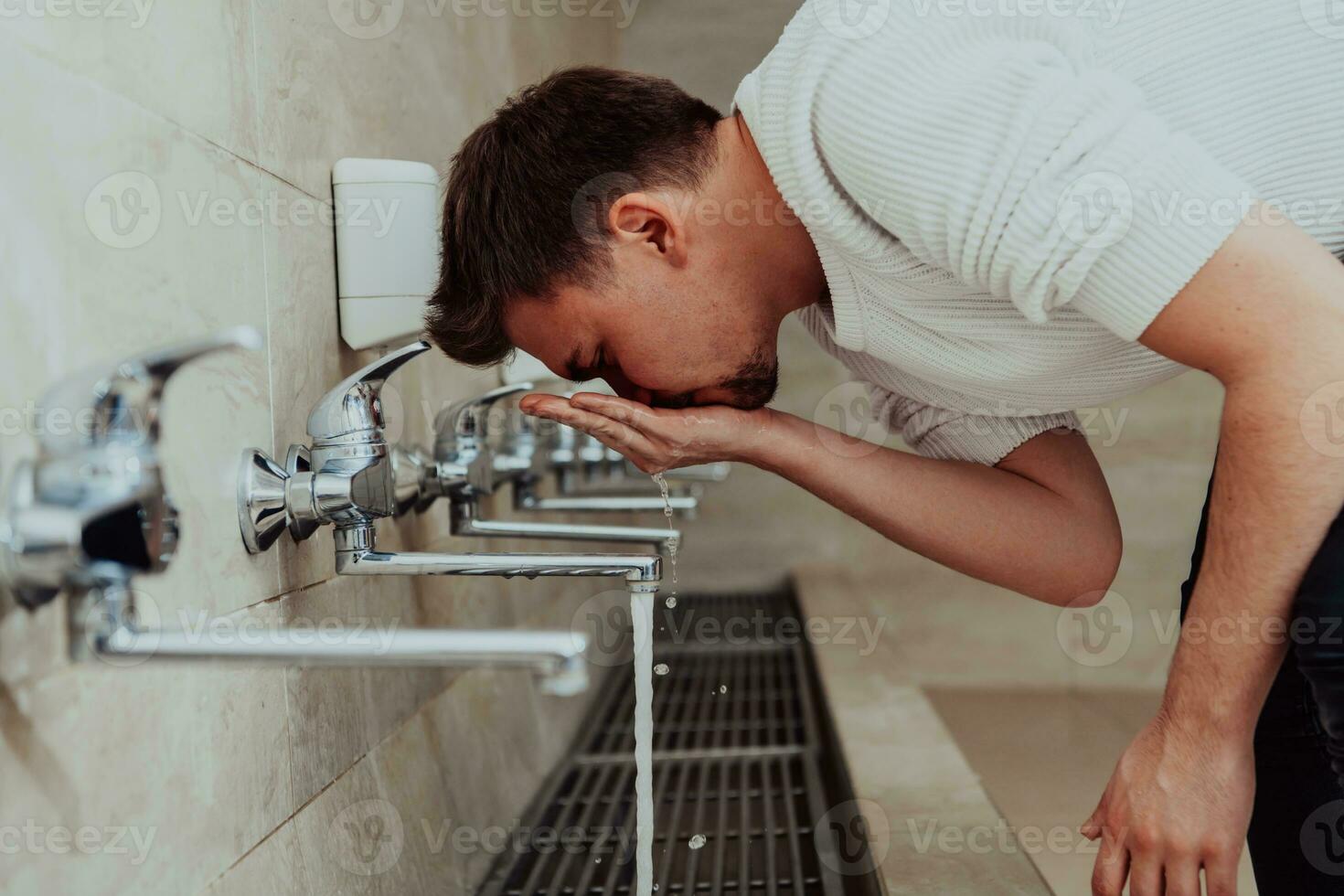 A Muslim performing ablution. Ritual religious cleansing of Muslims before performing prayer. The process of cleansing the body before prayer photo