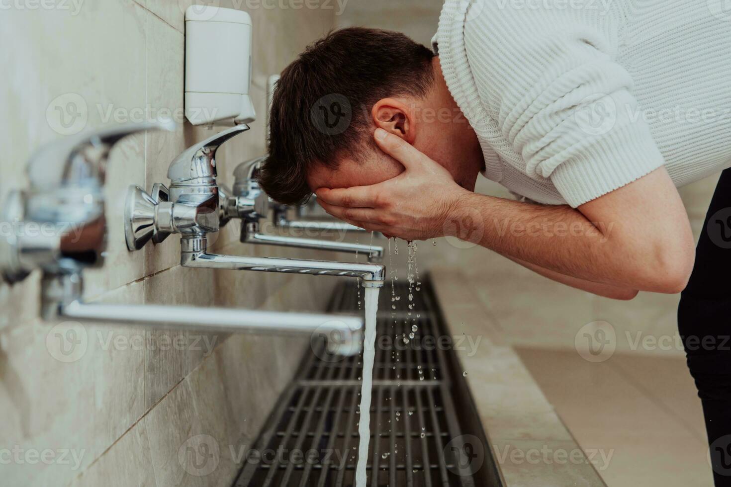 A Muslim performing ablution. Ritual religious cleansing of Muslims before performing prayer. The process of cleansing the body before prayer photo