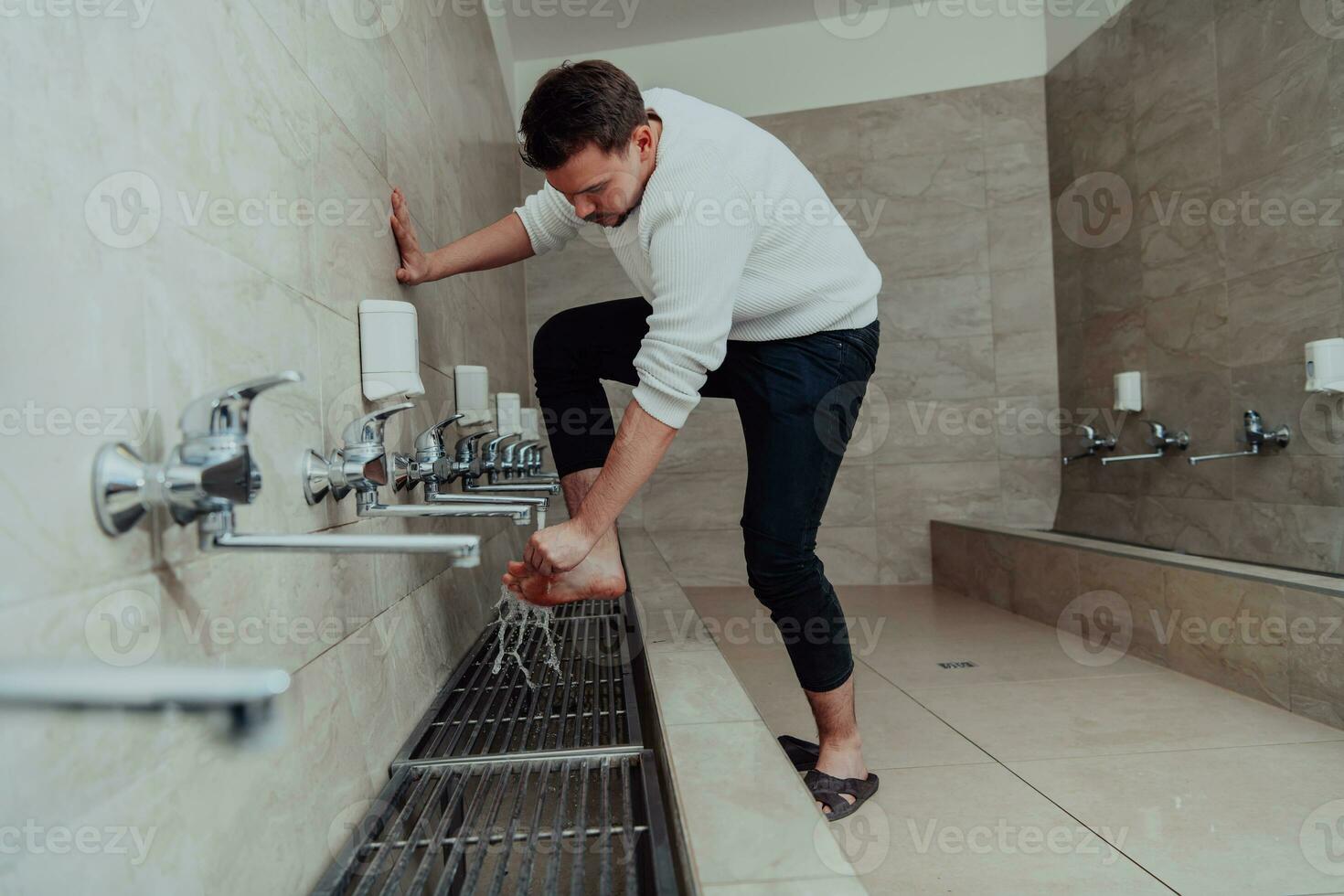 A Muslim performing ablution. Ritual religious cleansing of Muslims before performing prayer. The process of cleansing the body before prayer photo