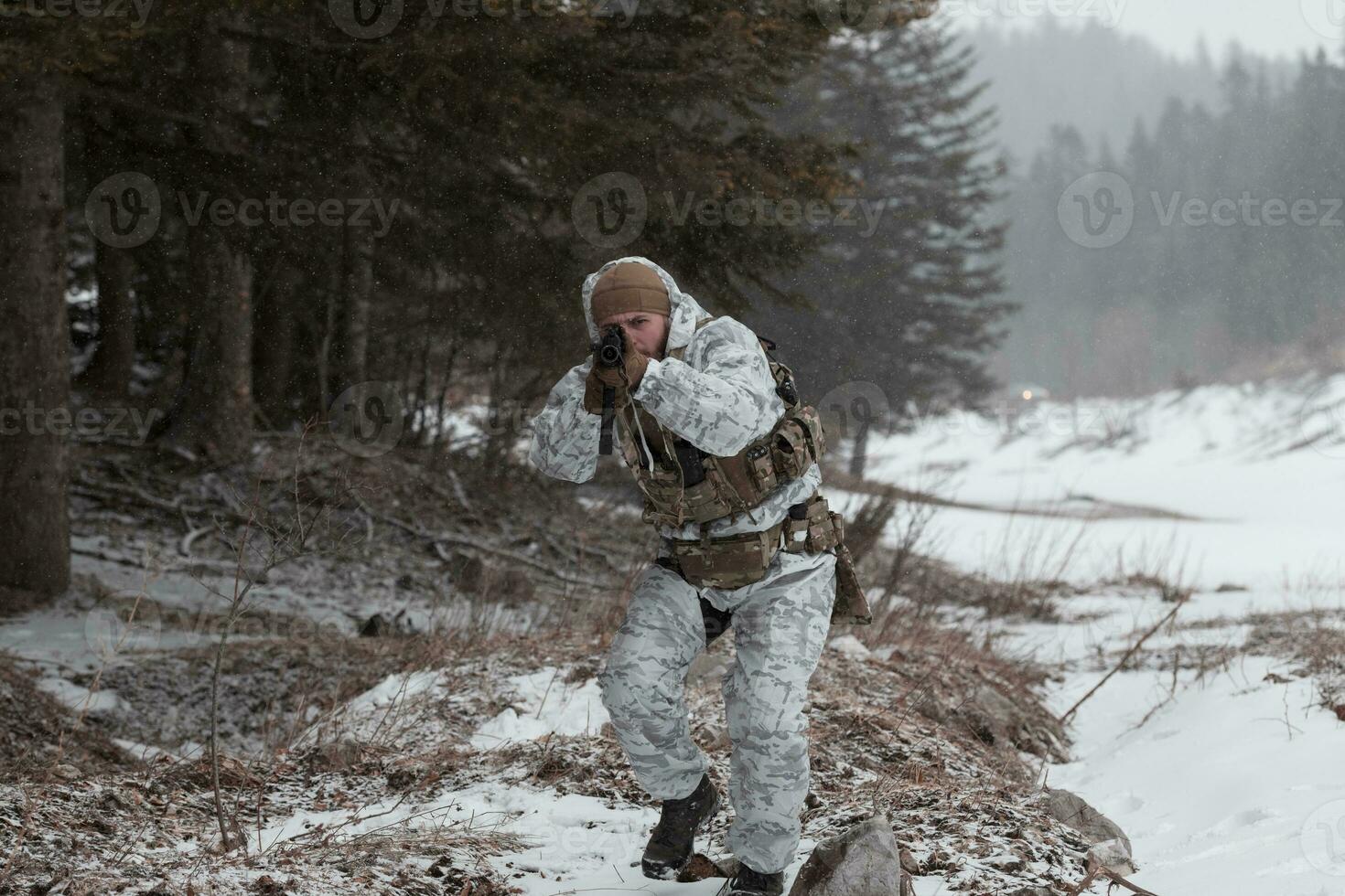 Winter war in the Arctic mountains. Operation in cold conditions.Soldier in winter camouflaged uniform in Modern warfare army on a snow day on forest battlefield with a rifle. Selective focus photo