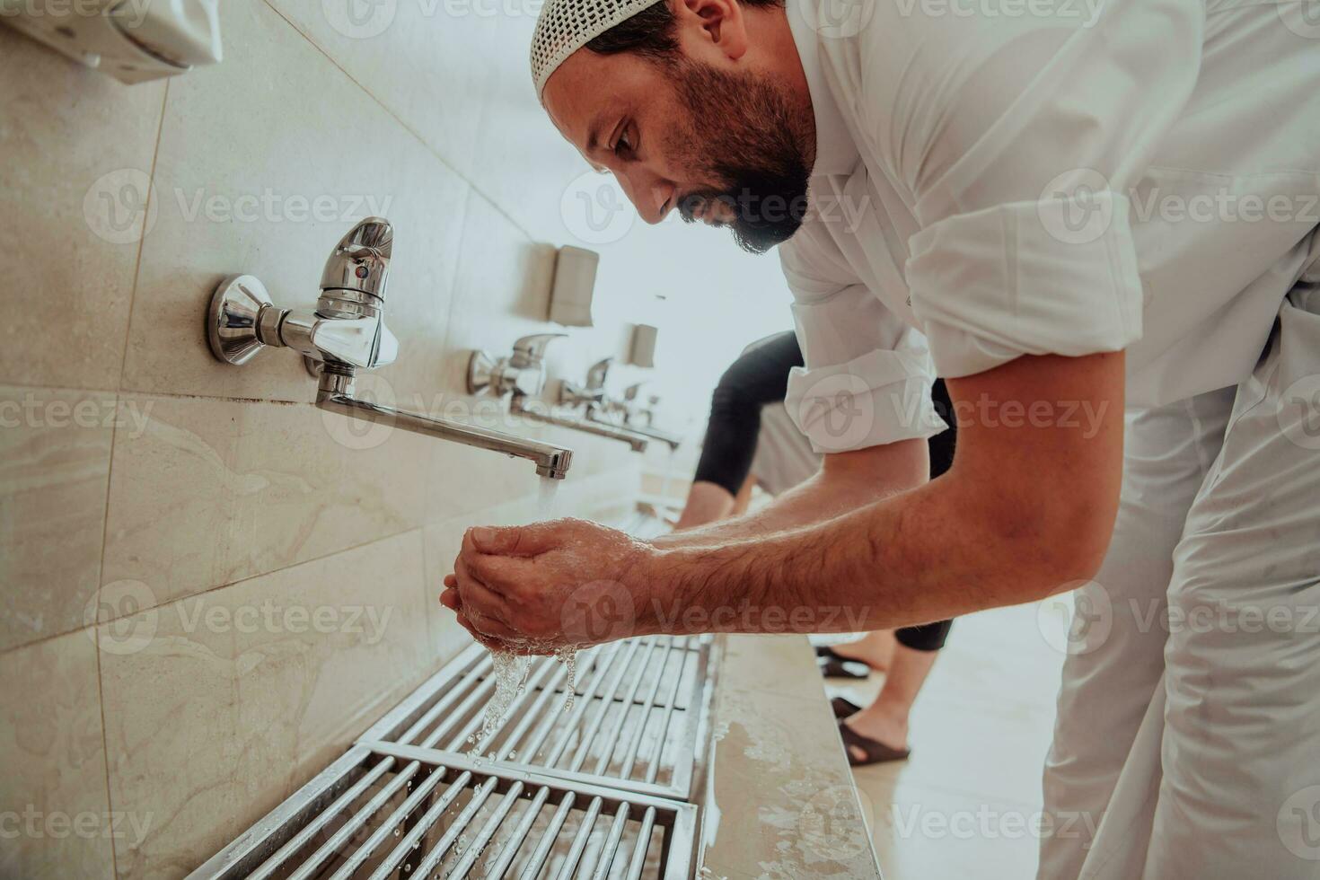 A Muslim performing ablution. Ritual religious cleansing of Muslims before performing prayer. The process of cleansing the body before prayer photo