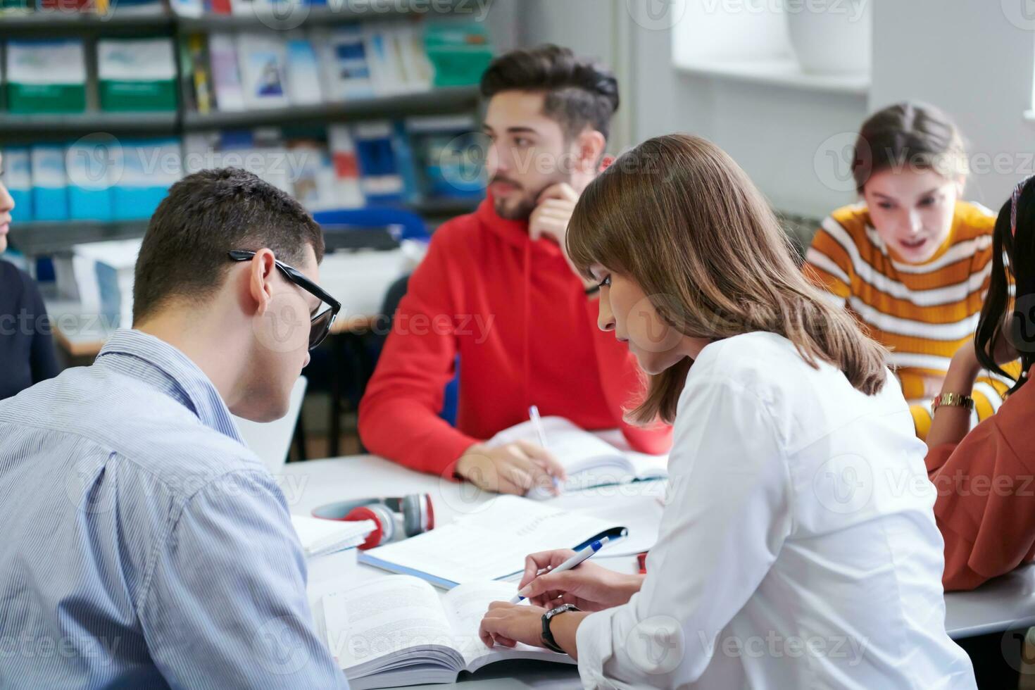 students group working on school project together on tablet computer at modern university photo
