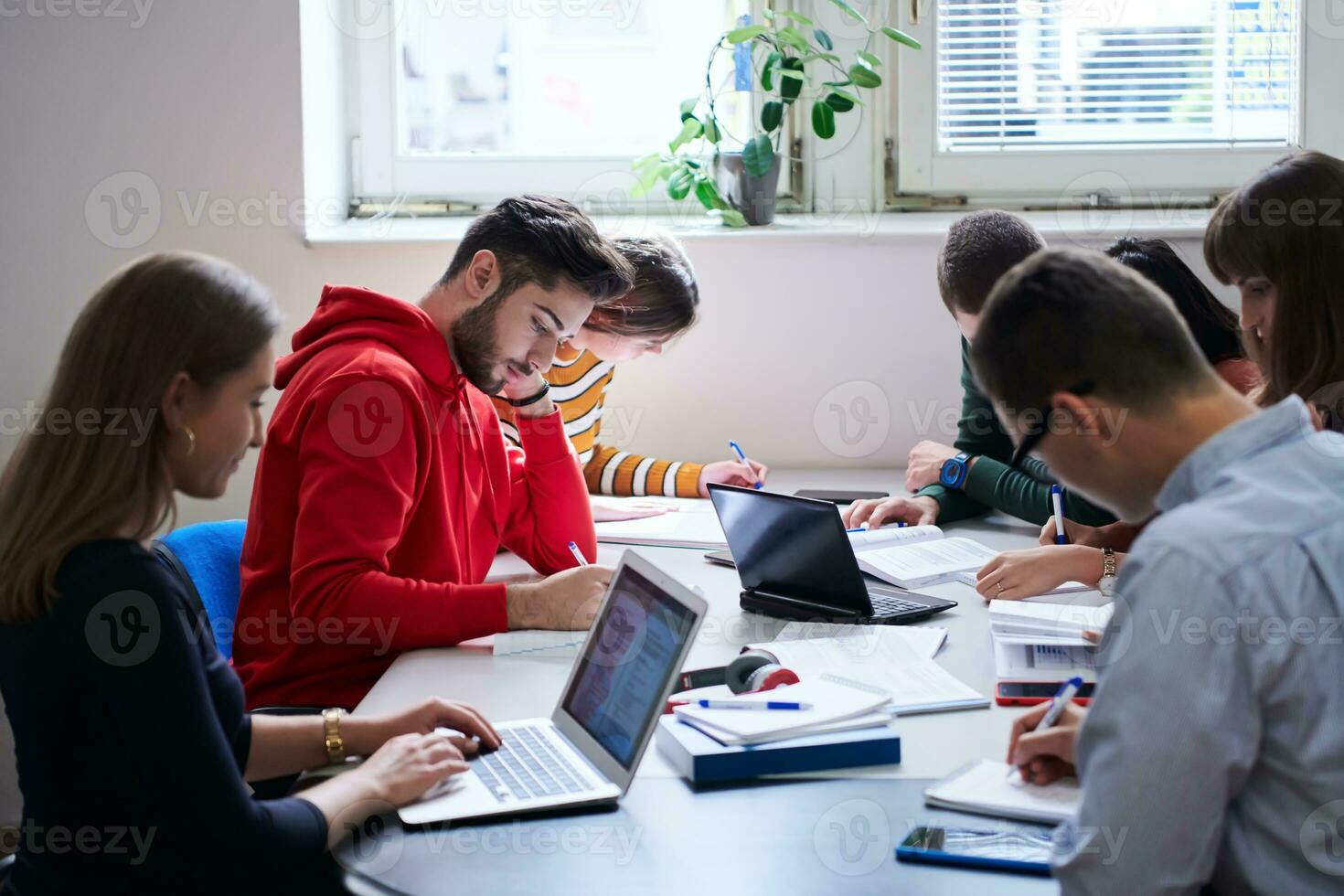 students group working on school project together on tablet computer at modern university photo