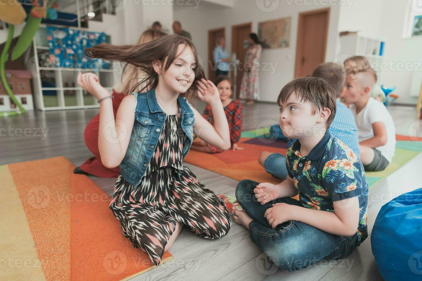 A girl and a boy with Down's syndrome in each other's arms spend time together in a preschool institution photo