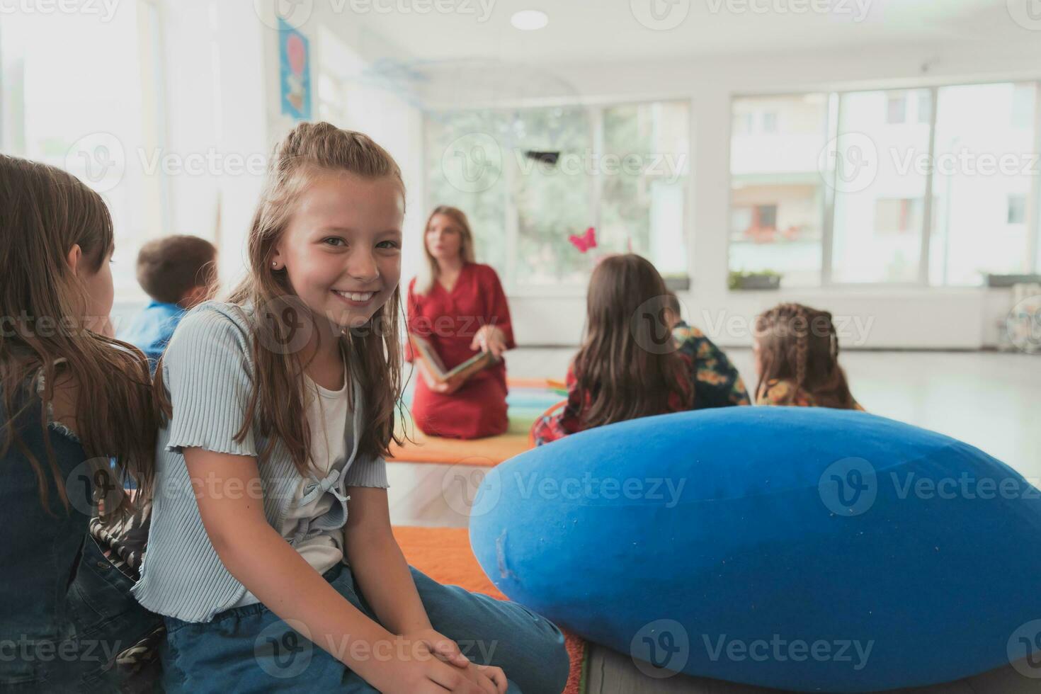 leyendo hora en un elemental colegio o jardín de infancia, un profesor lee un libro a niños en un elemental colegio o jardín de infancia. el concepto de preescolar educación. selectivo atención foto