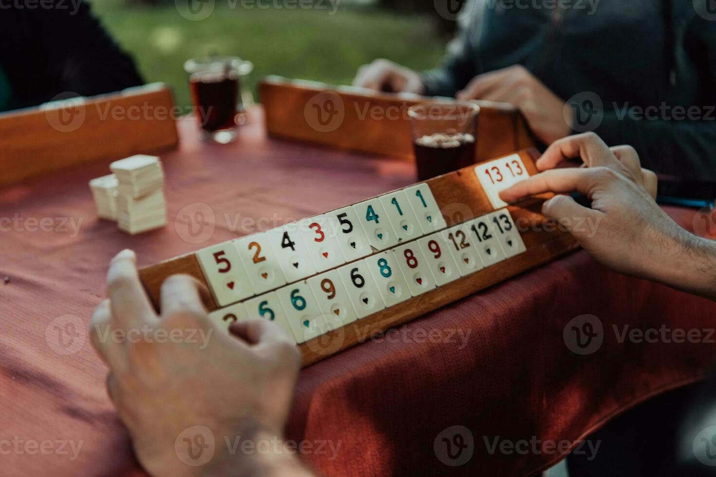 A group of men drink traditional Turkish tea and play a Turkish game called Okey photo