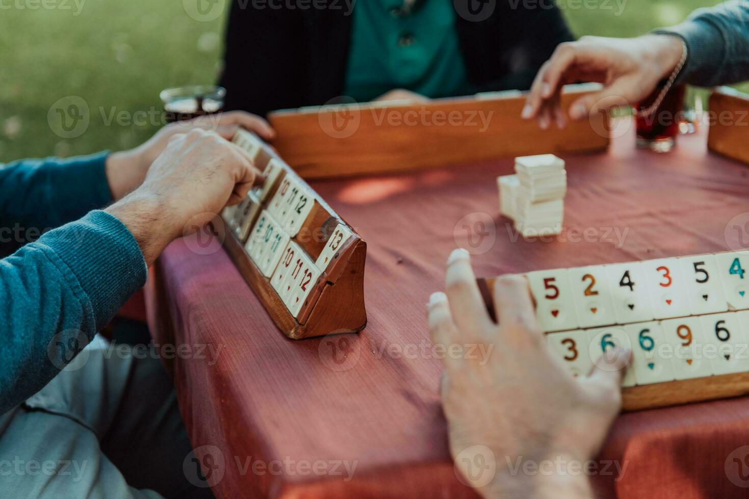 A group of men drink traditional Turkish tea and play a Turkish game called Okey photo