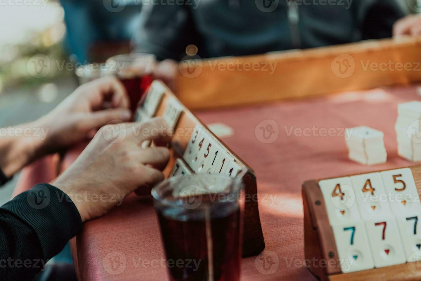 A group of men drink traditional Turkish tea and play a Turkish game called Okey photo