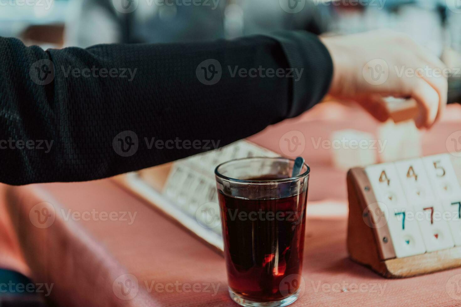 A group of men drink traditional Turkish tea and play a Turkish game called Okey photo