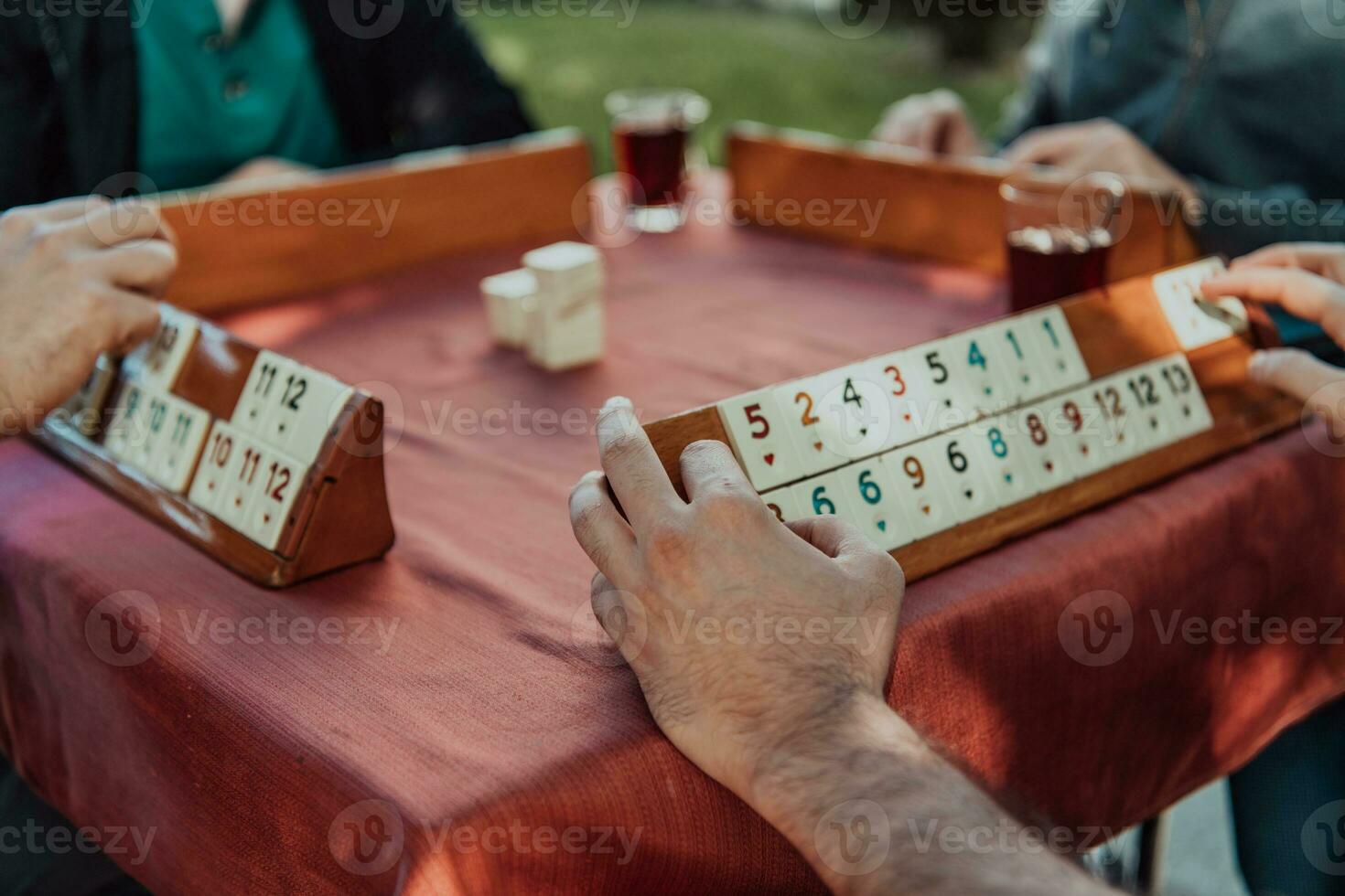 A group of men drink traditional Turkish tea and play a Turkish game called Okey photo