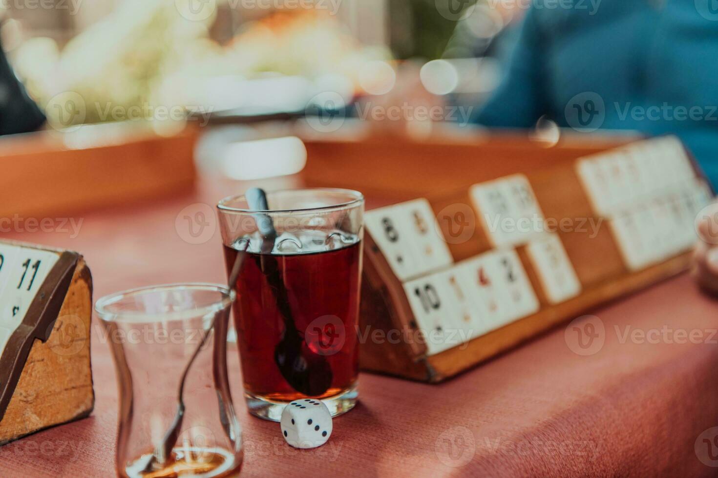 A group of men drink traditional Turkish tea and play a Turkish game called Okey photo