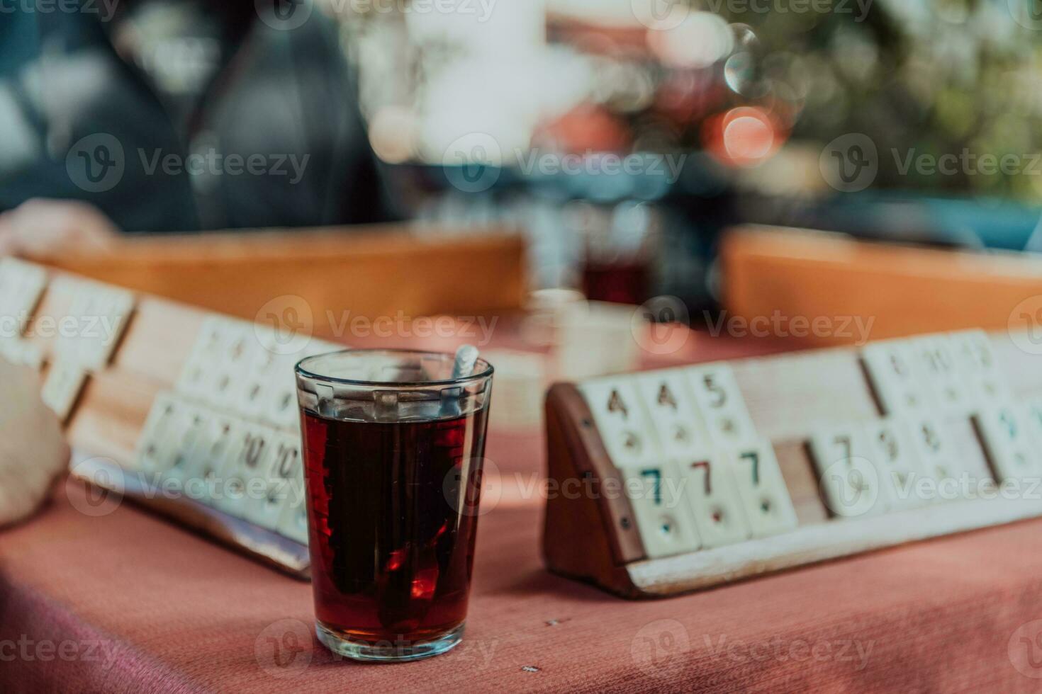 A group of men drink traditional Turkish tea and play a Turkish game called Okey photo