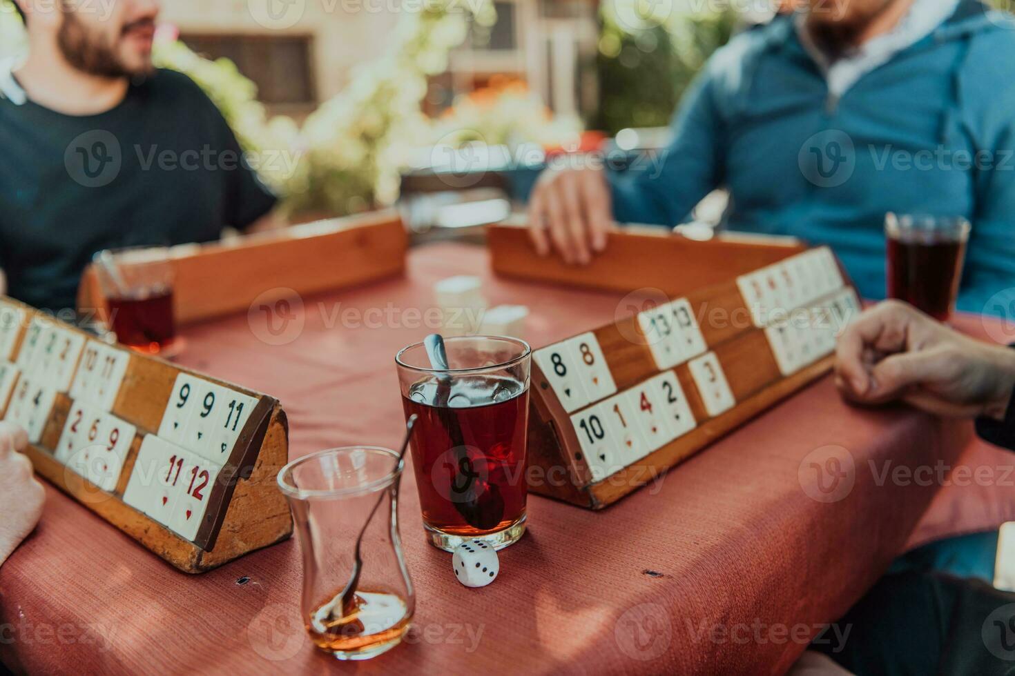 A group of men drink traditional Turkish tea and play a Turkish game called Okey photo