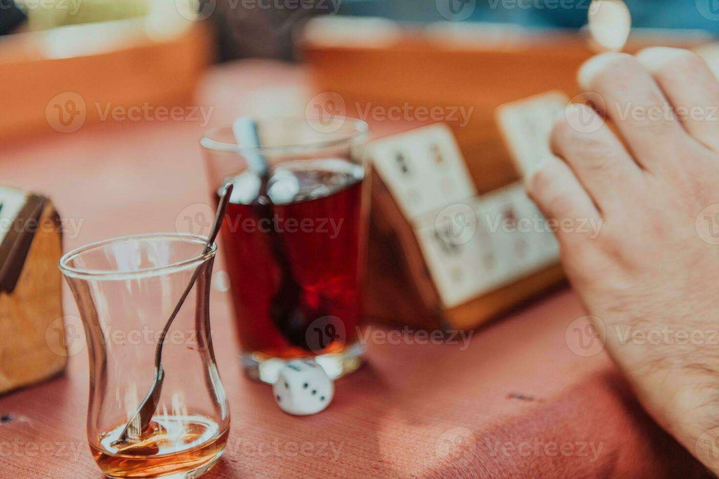 A group of men drink traditional Turkish tea and play a Turkish game called Okey photo