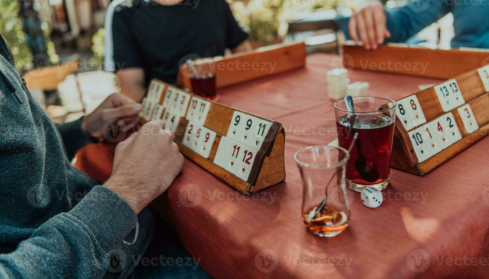 A group of men drink traditional Turkish tea and play a Turkish game called Okey photo