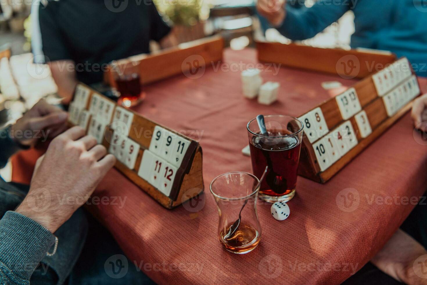 A group of men drink traditional Turkish tea and play a Turkish game called Okey photo