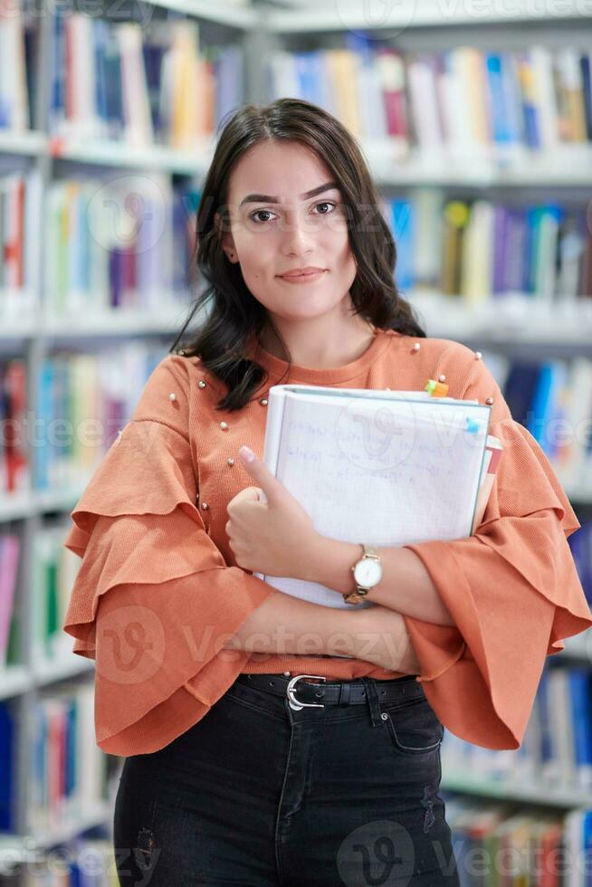the student uses a notebook and a school library photo