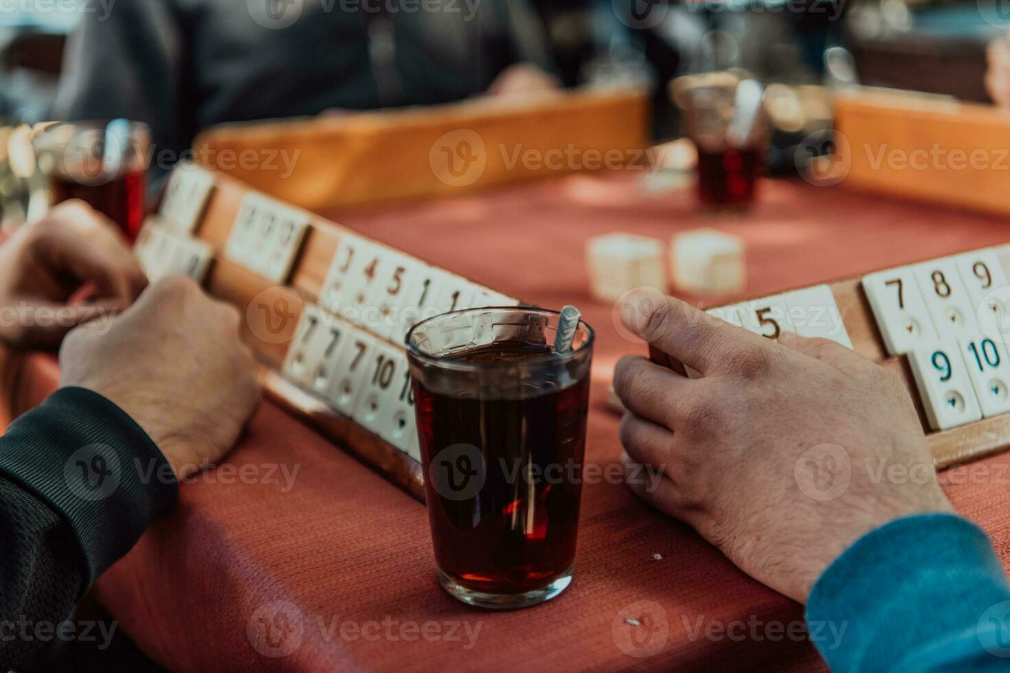 A group of men drink traditional Turkish tea and play a Turkish game called Okey photo