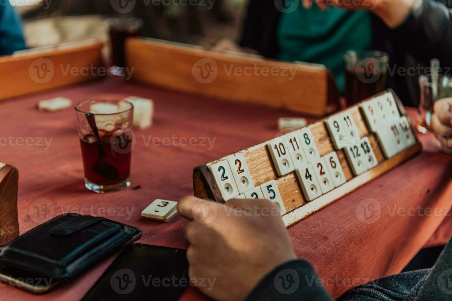 A group of men drink traditional Turkish tea and play a Turkish game called Okey photo