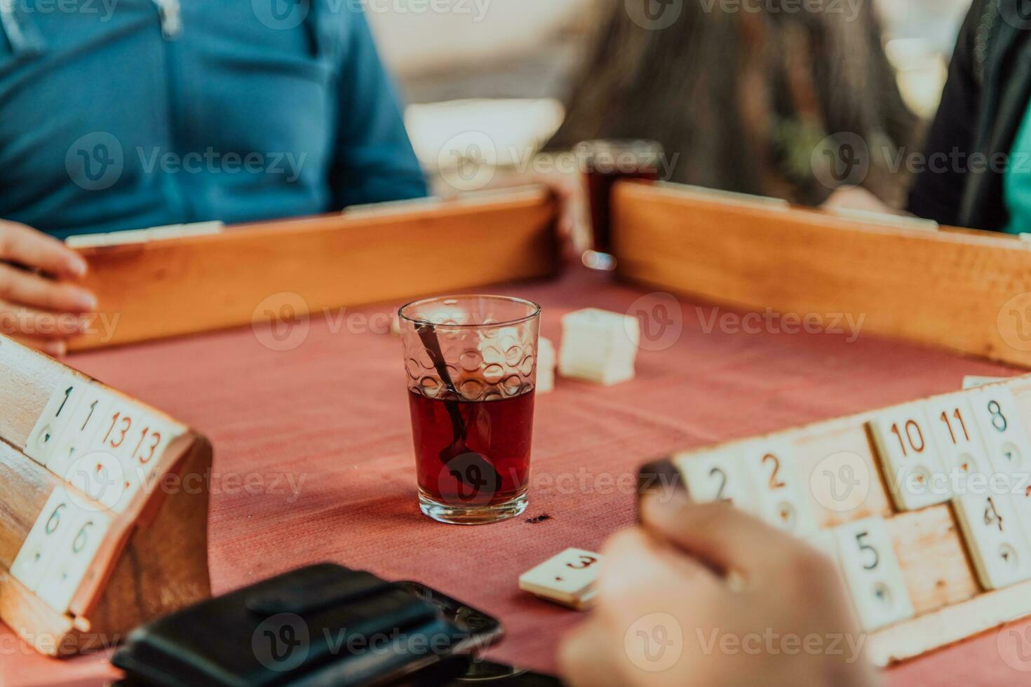 A group of men drink traditional Turkish tea and play a Turkish game called Okey photo