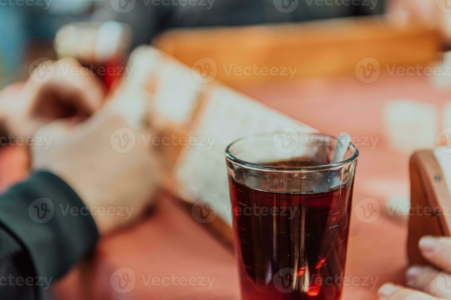 A group of men drink traditional Turkish tea and play a Turkish game called Okey photo