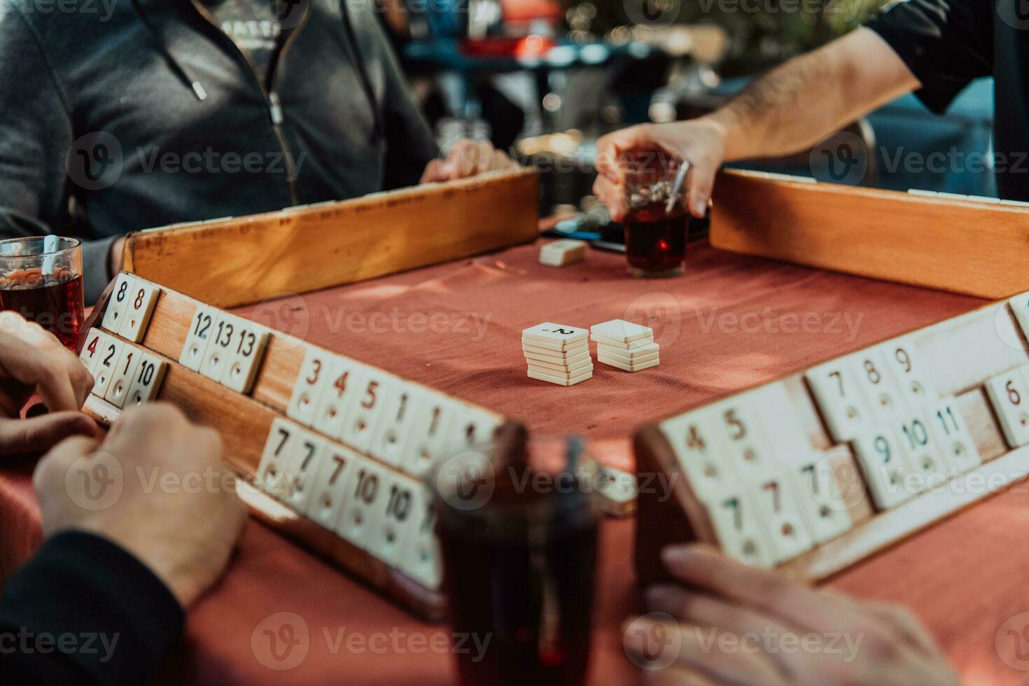 A group of men drink traditional Turkish tea and play a Turkish game called Okey photo