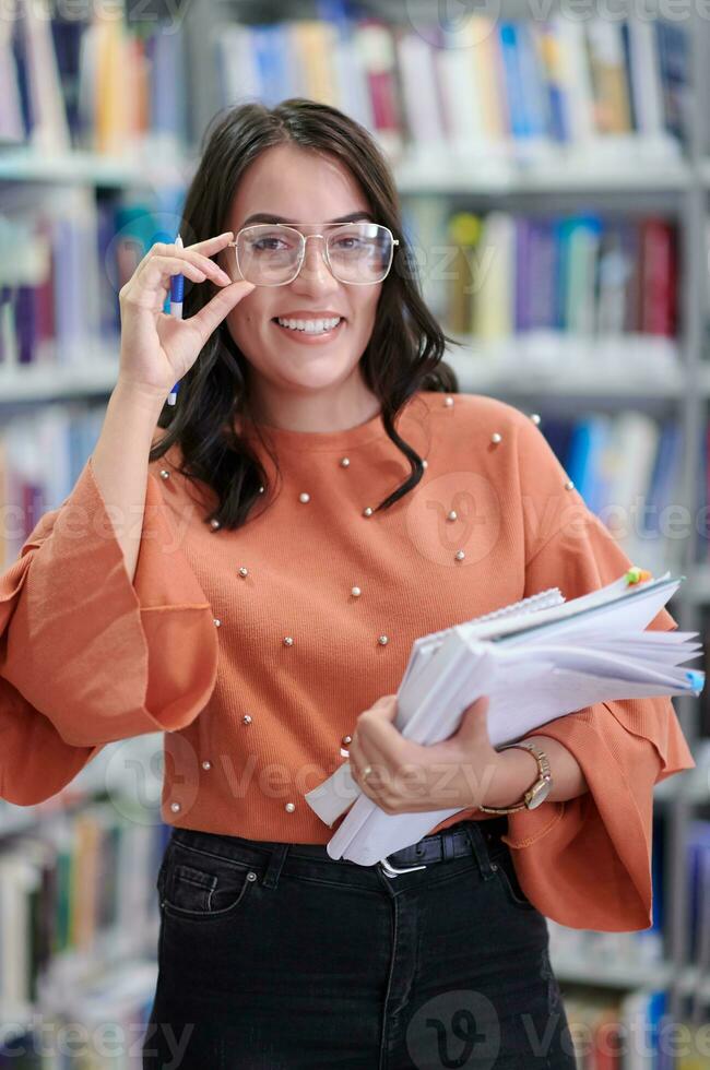 the student uses a notebook and a school library photo