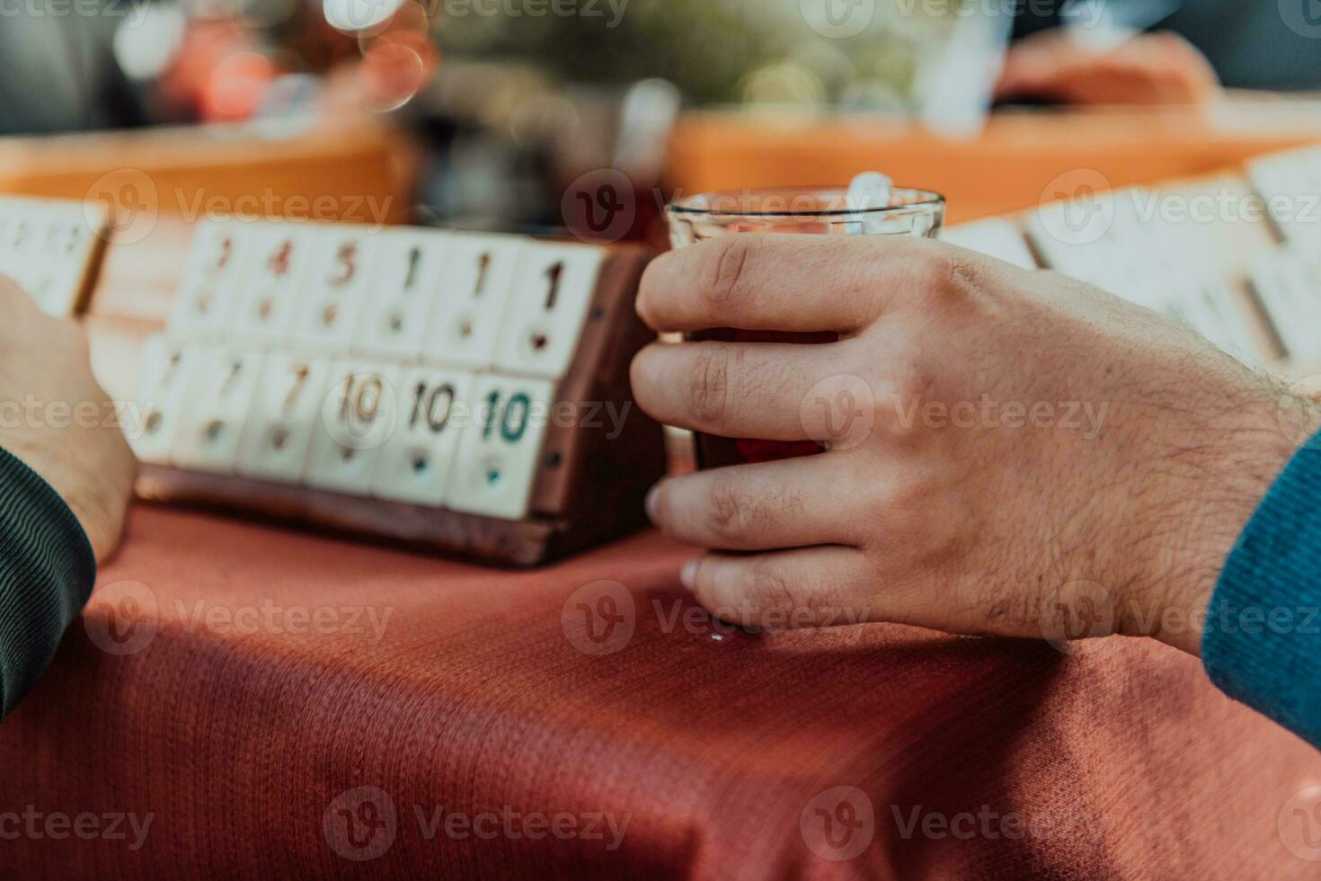 A group of men drink traditional Turkish tea and play a Turkish game called Okey photo