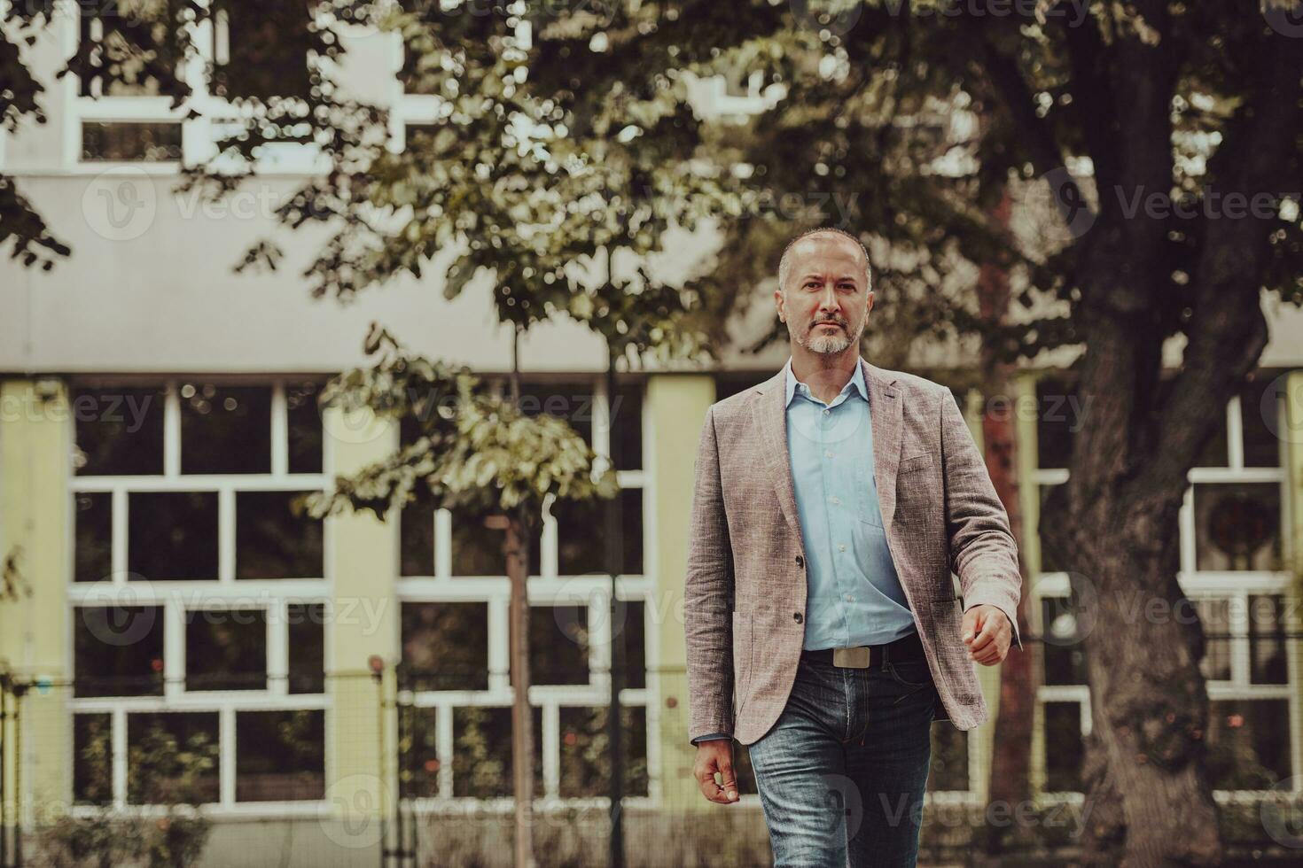 focused businessman in suit walking in urban environment. photo