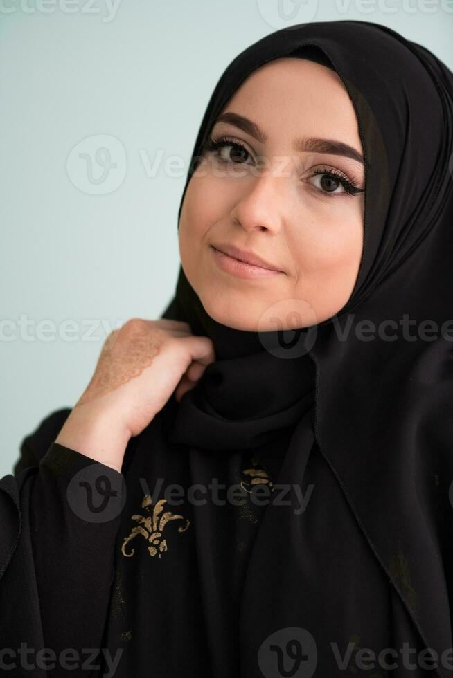 hermosa musulmán mujer en de moda vestir con hijab aislado en moderno cian antecedentes representando concepto de moderno islam y Ramadán kareem foto