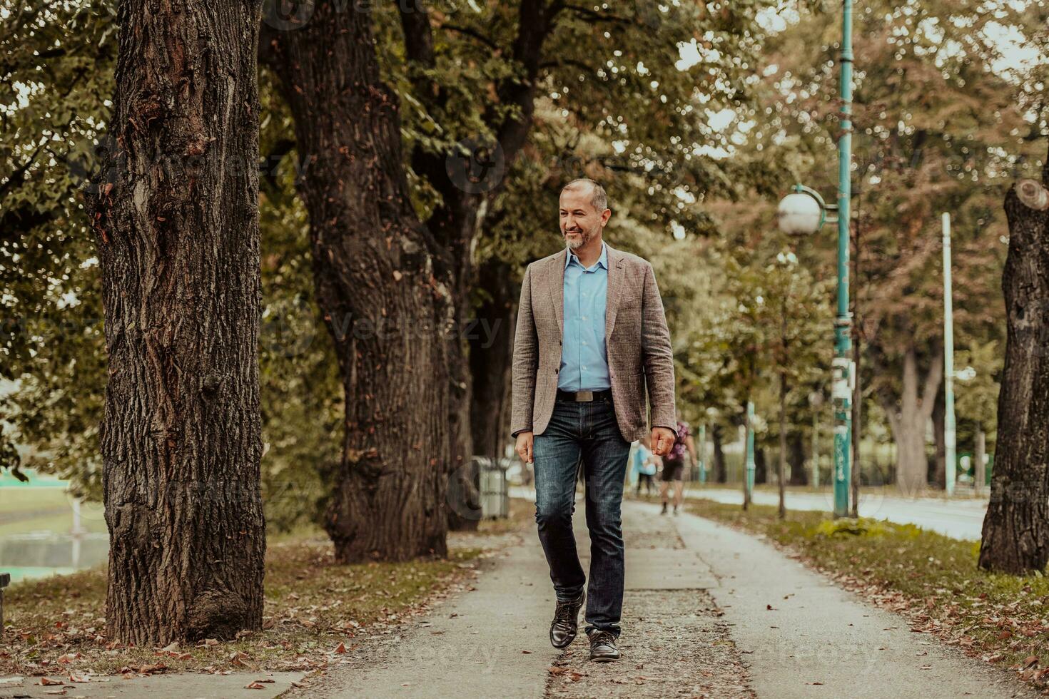 Focused businessman in a suit walking in the park photo