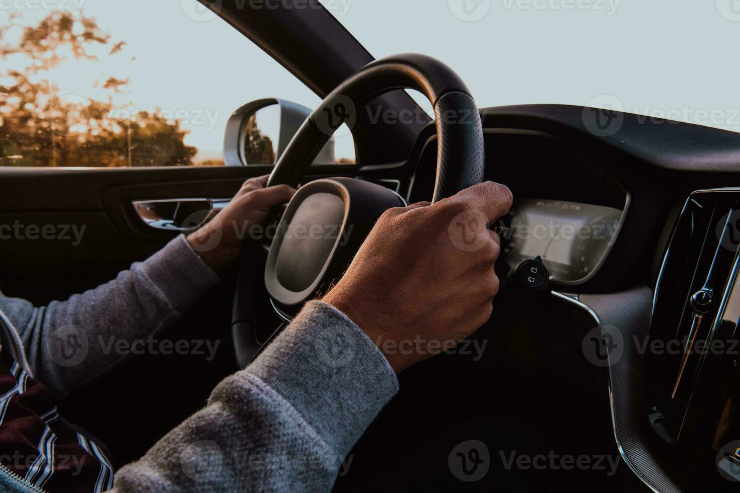 Close up man hand driving a car at sunset. The concept of car travel photo