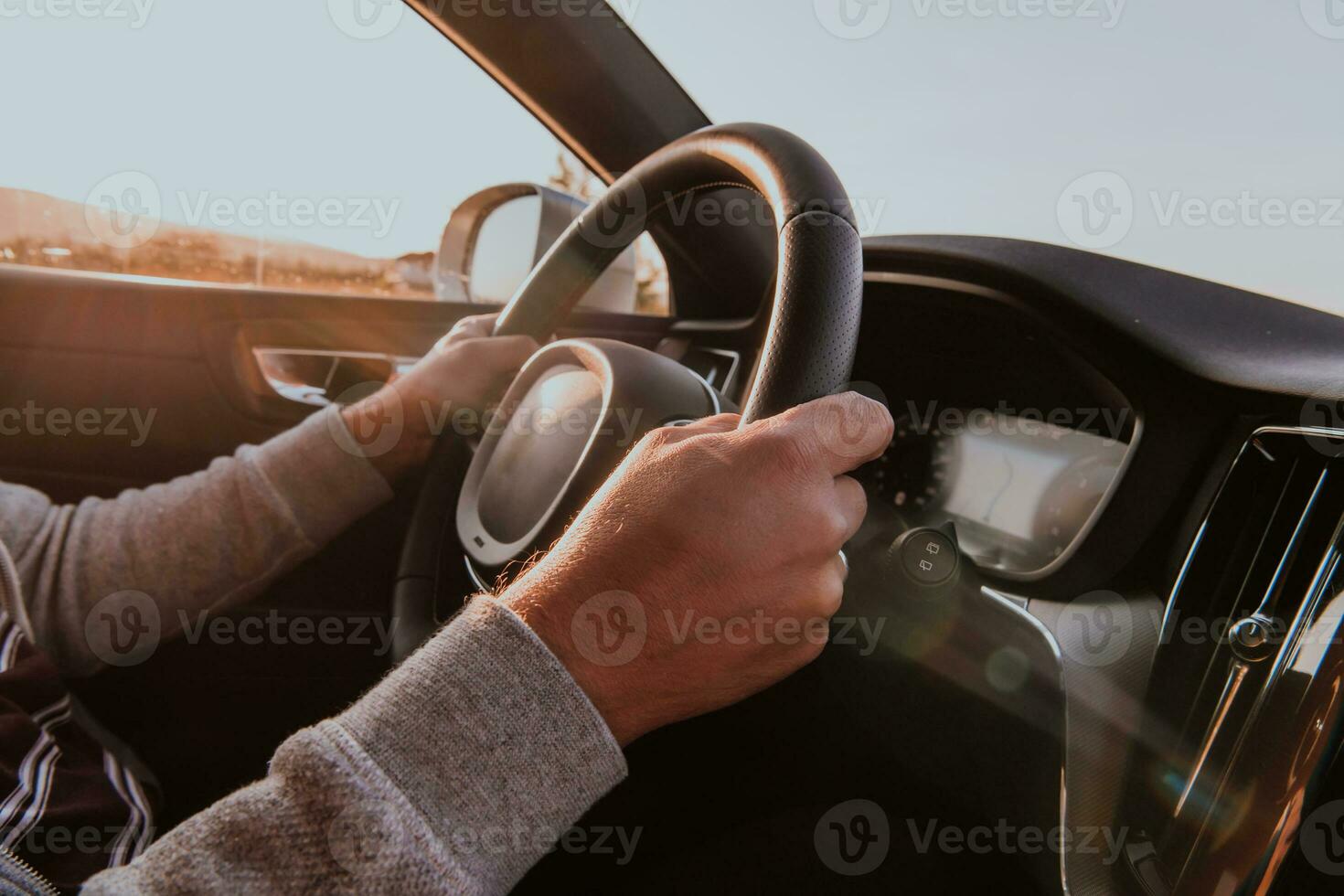 cerca arriba hombre mano conducción un coche a puesta de sol. el concepto de coche viaje foto