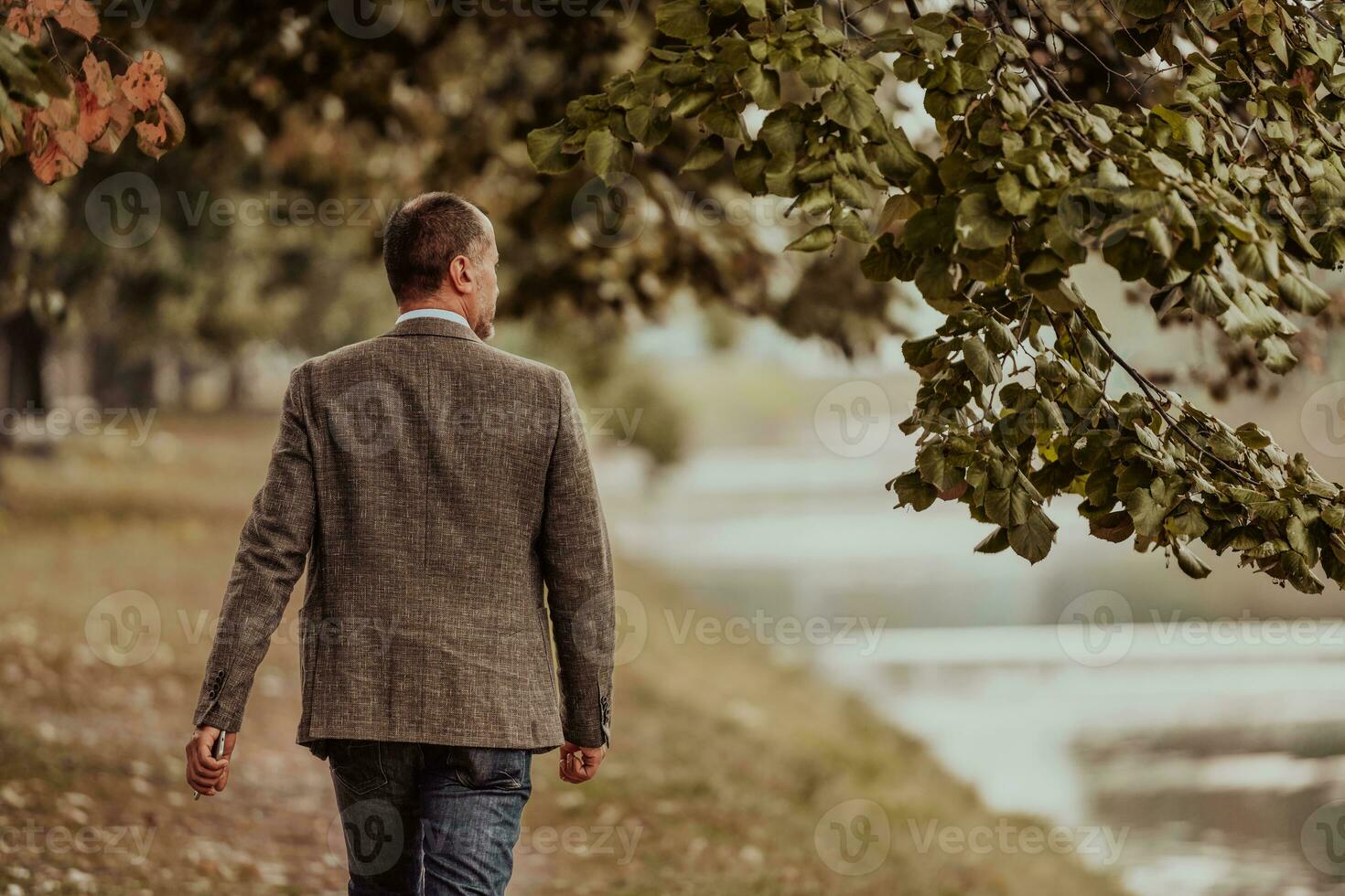 Focused businessman in a suit walking in the park photo