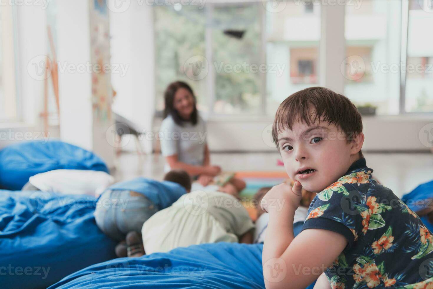 A boy with Down's syndrome spend time together in a preschool institution and play games photo