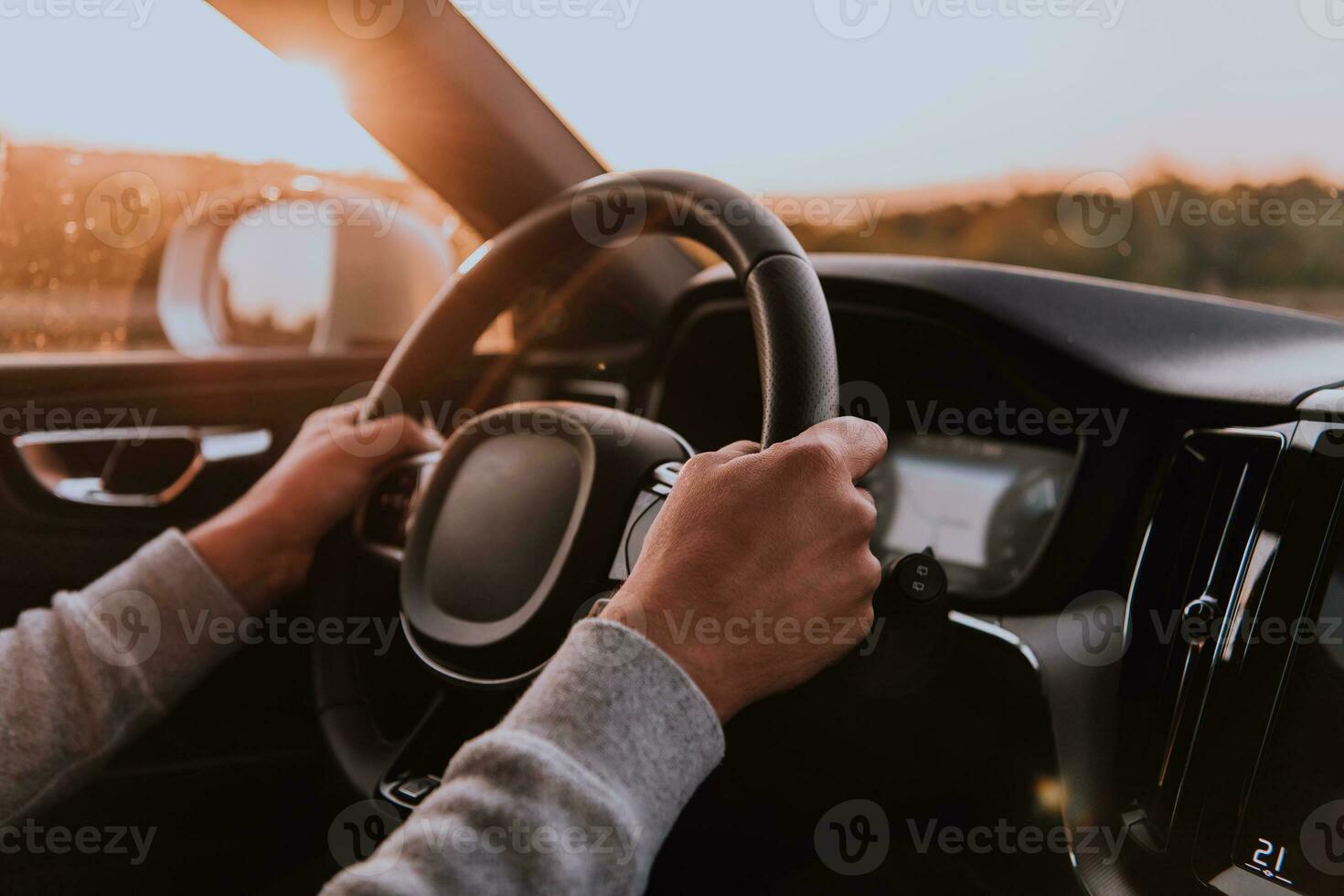 Close up man hand driving a car at sunset. The concept of car travel photo