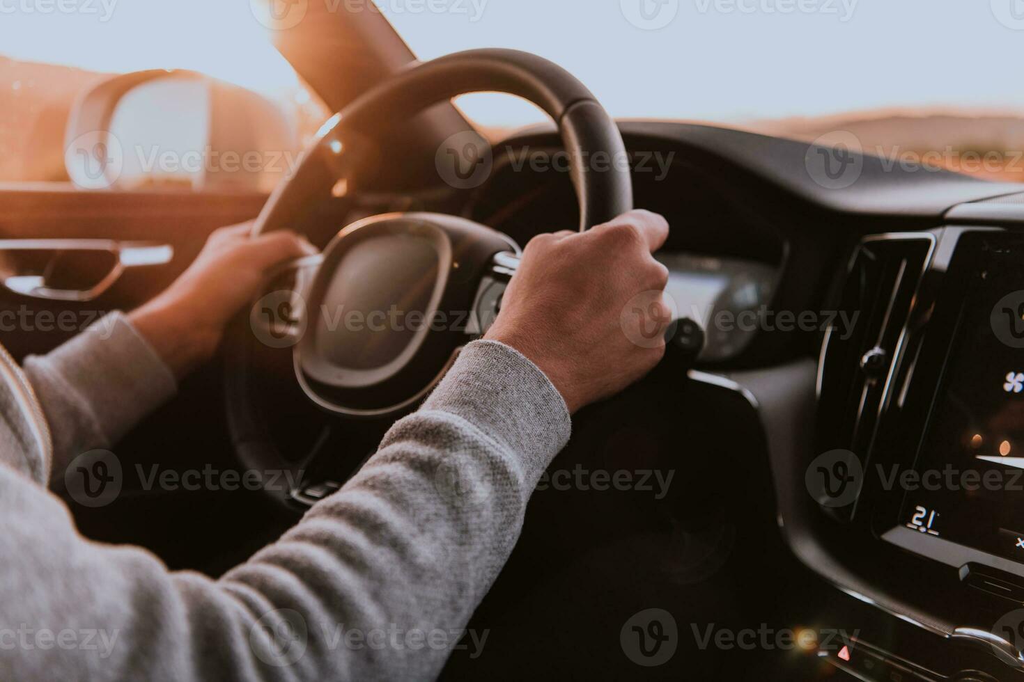 Close up man hand driving a car at sunset. The concept of car travel photo