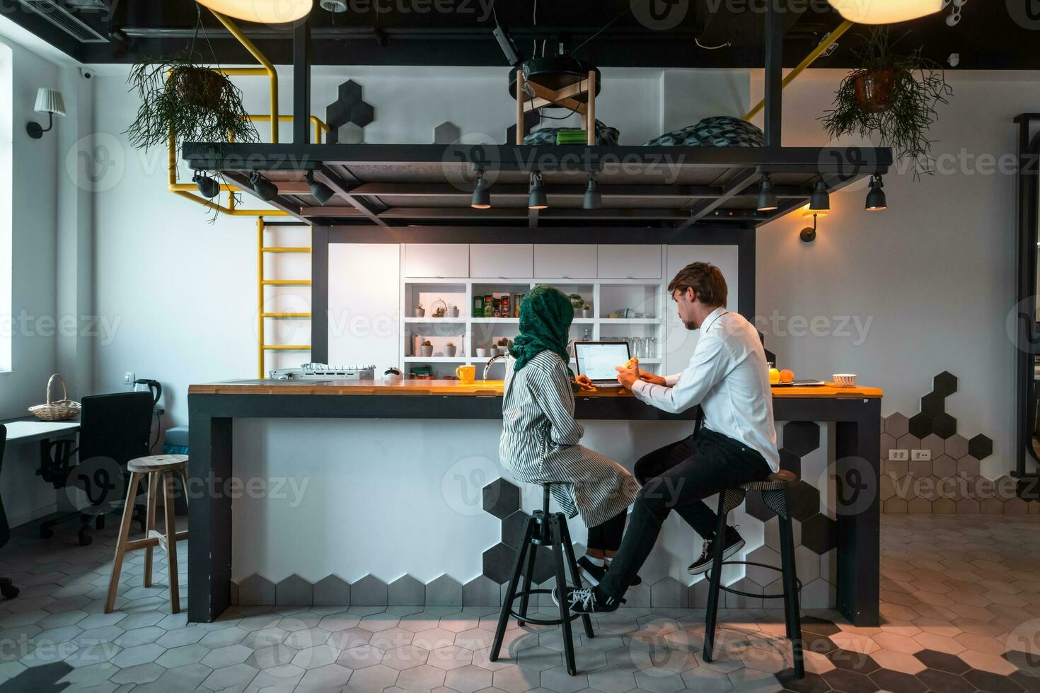 Group of casual multiethnic business people taking break from the work doing different things while enjoying free time in relaxation area at modern open plan startup office photo