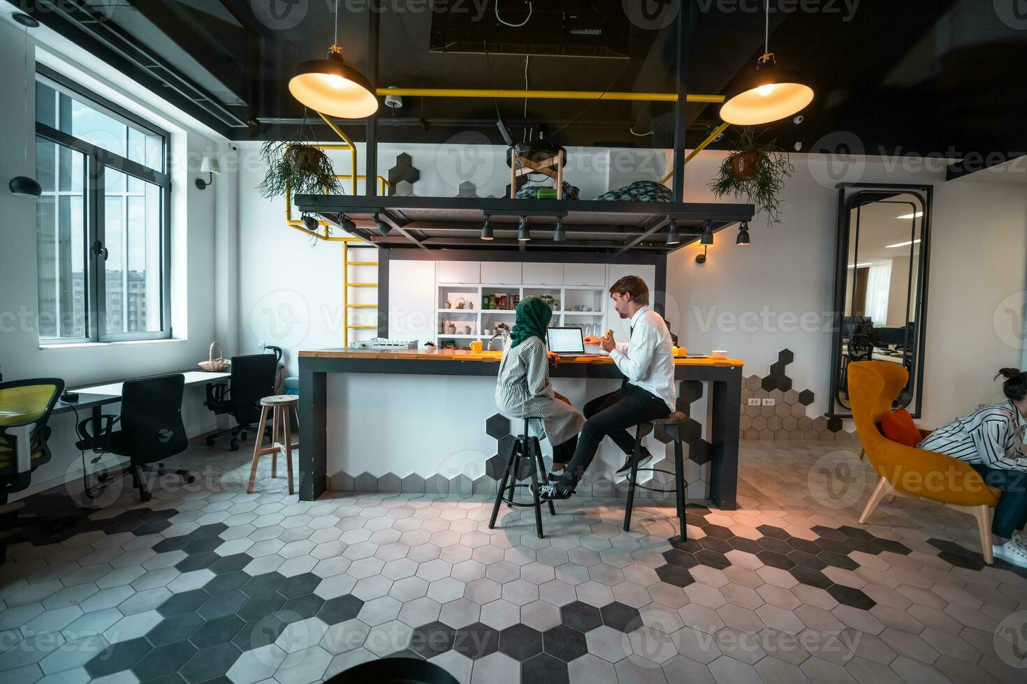 Group of casual multiethnic business people taking break from the work doing different things while enjoying free time in relaxation area at modern open plan startup office photo