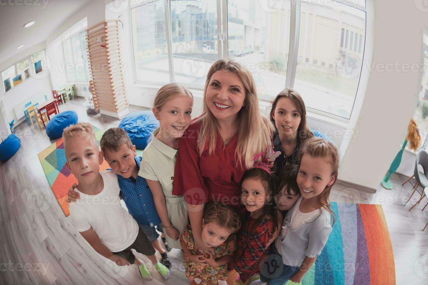 foto de niños en un preescolar institución en pie en el salón de clases juntos con el profesor