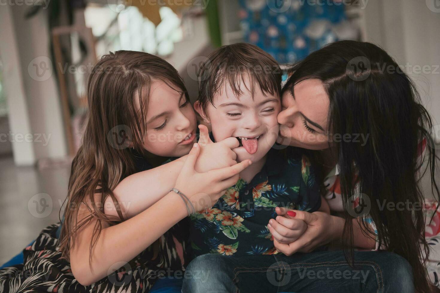 A girl and a woman hug a child with down syndrome in a modern preschool institution photo