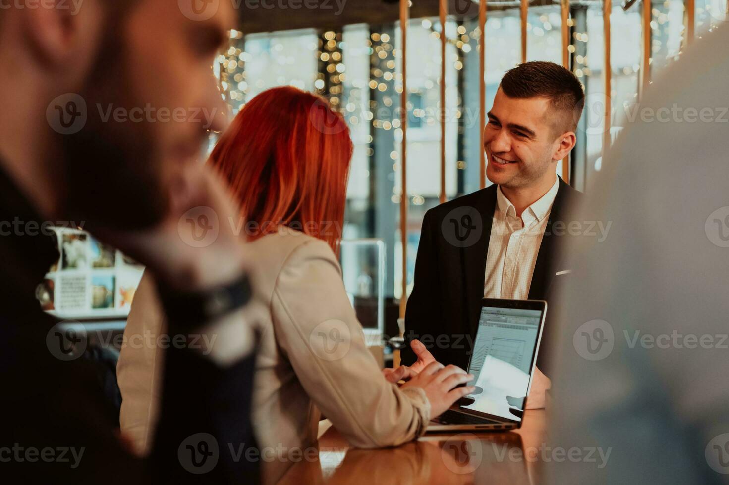 Group of business people hanging out in a coffee shop with a laptop amongst them. photo