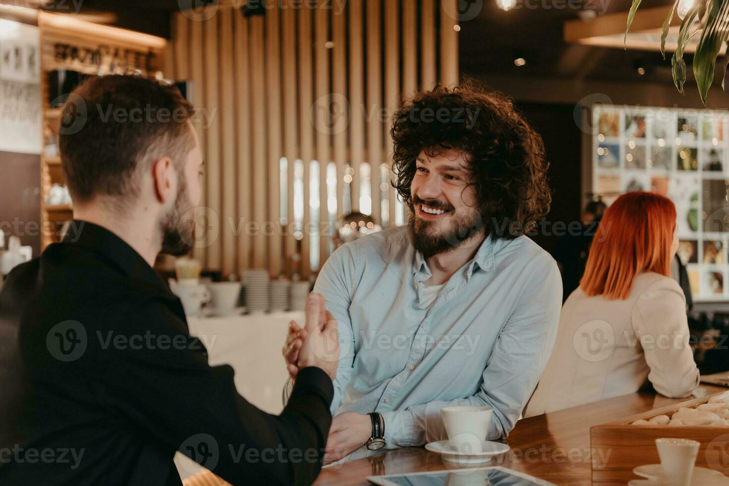 A group of friends hanging out in a cafe, and among them is a tablet. photo